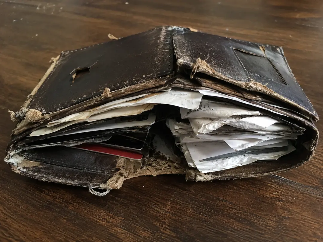 Carteira financeira rasgada e desorganizada de um maker 3D, notas e papeis espalhados